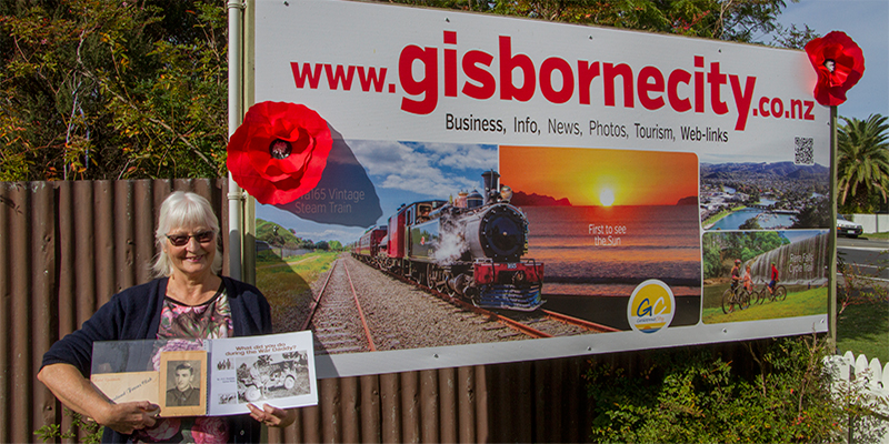 Gisborne city. Beth with Poppies on Sign 'We shall remember them"
